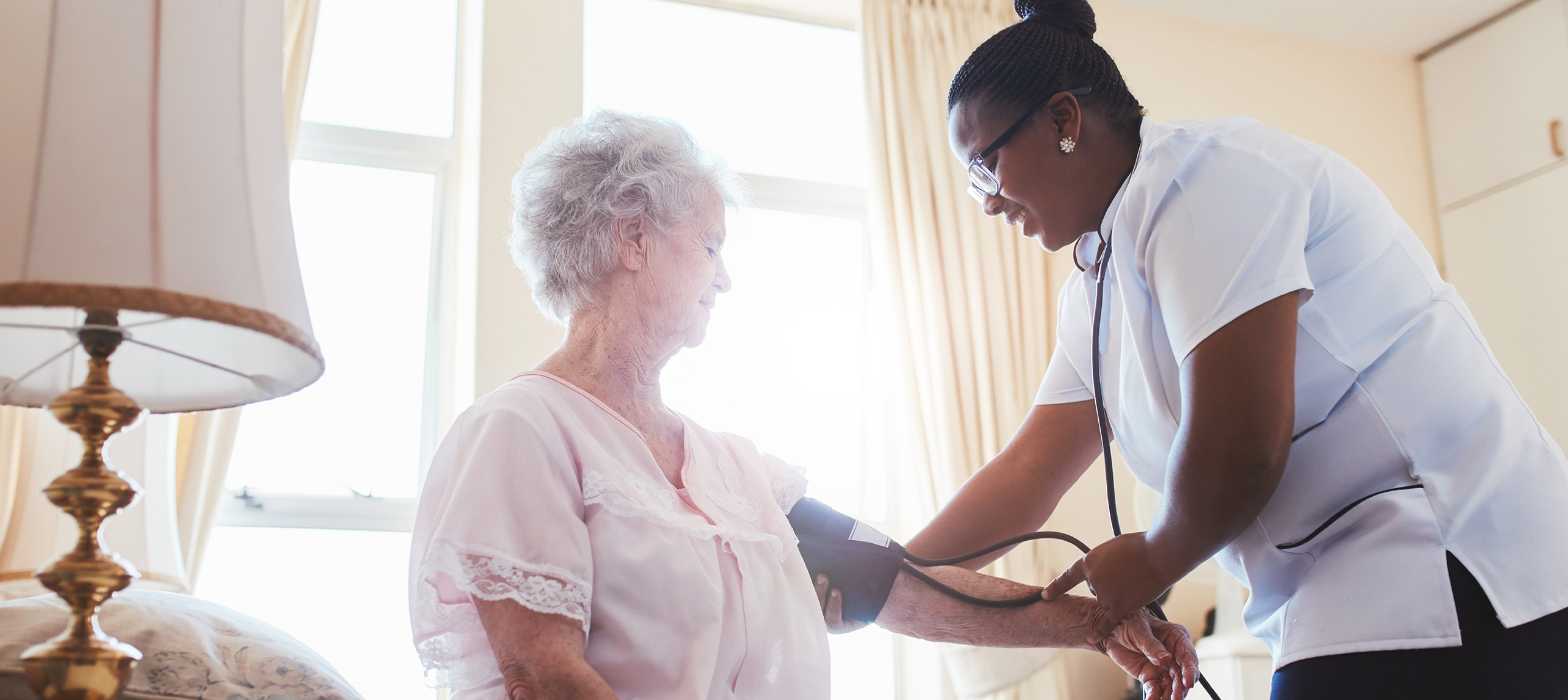 A nurse takes a residents blood pressure