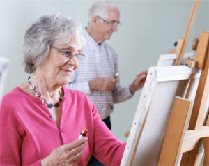 Two residents paint during art class