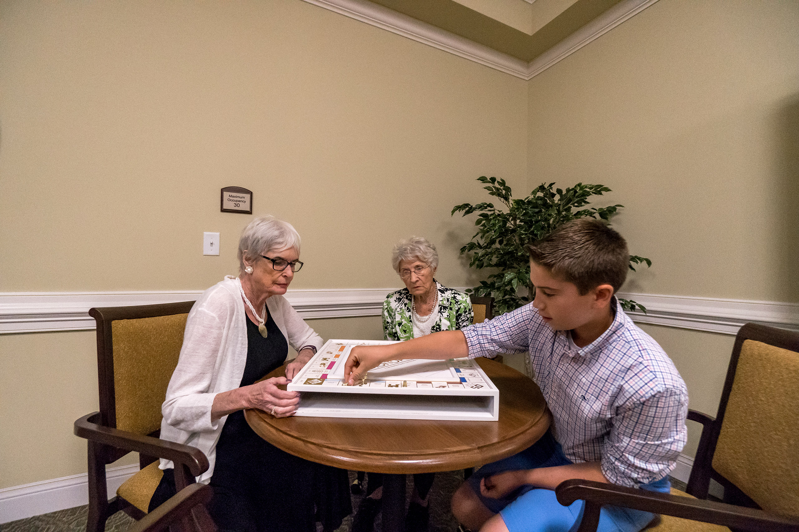 Residents playing Monopoly with her Grandson in game room