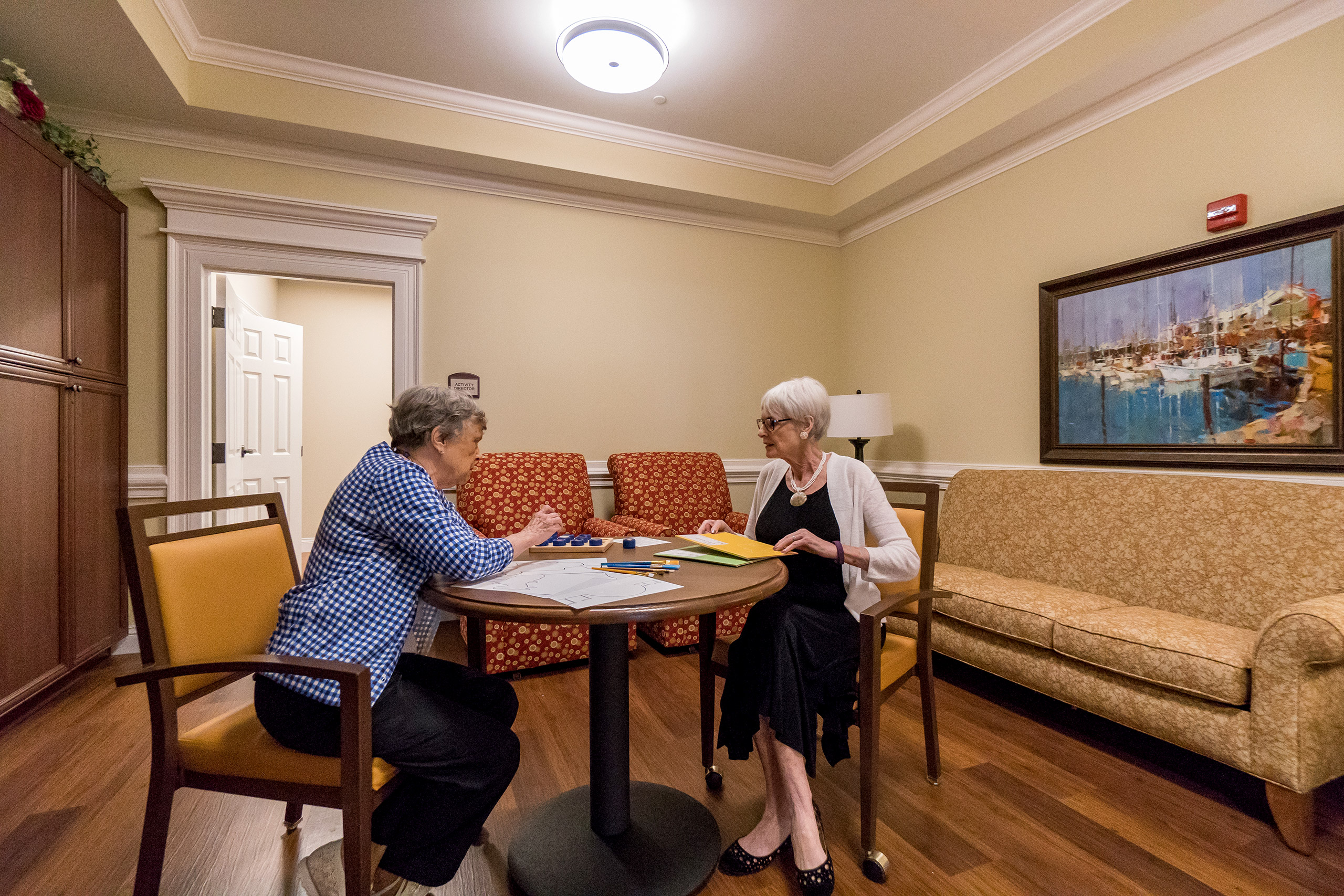 Two residents enjoy games in the Memory Care lounge