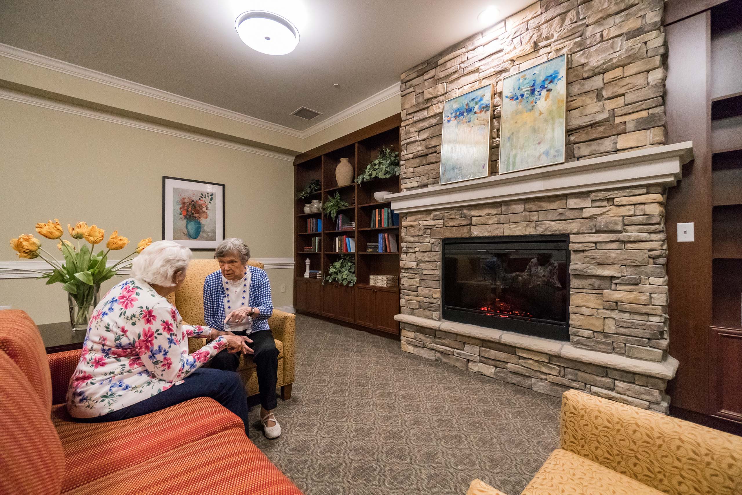 Residents sit by the fire in the Emerson Room lounge